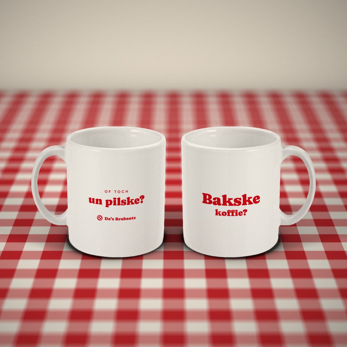 Voor- en achterkant: twee witte mokken „Bakske koffie?” naast elkaar op een rood-wit geruit tafelkleed