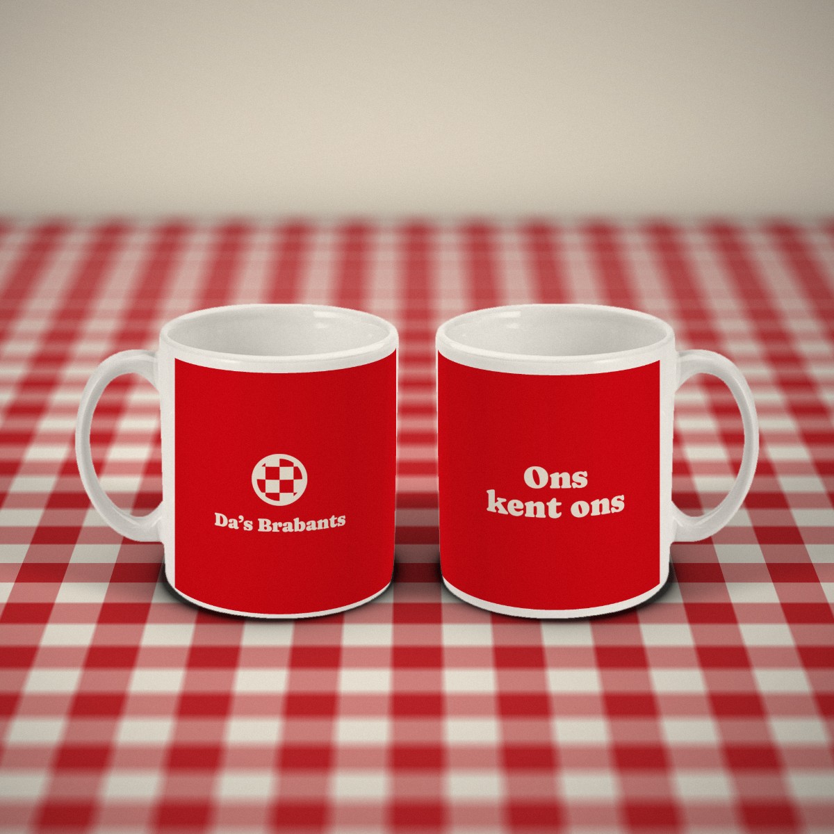 Voor- en achterkant: twee rode mokken „Ons kent ons” naast elkaar op een rood-wit geruit tafelkleed