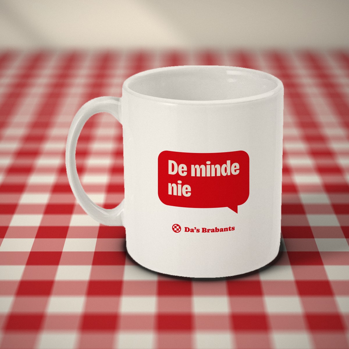 Achterkant: witte mok met een rood tekstballonnetje met „De minde nie” en het logo van Da's Brabants