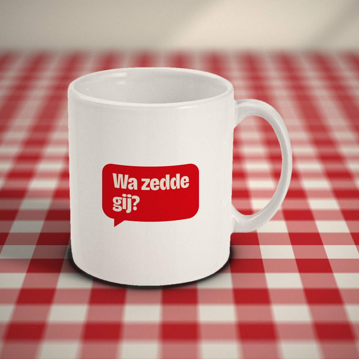 Voorkant: witte mok met een rood tekstballonnetje met „Wa zedde gij?”, op een rood-wit geruit tafelkleed