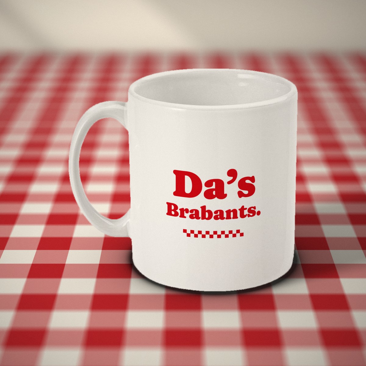 Achterkant: witte mok met in rode letters „Da's Brabants.” en een geblokt randje